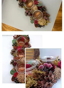 Detailed view of festive candle holder with pine cones, red roses, and glass cups