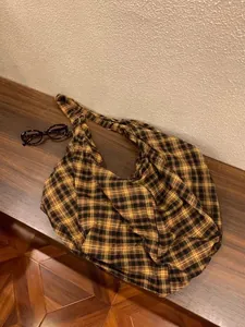 Vue détaillée d'un sac hobo en toile à carreaux jaunes et noirs au style rétro décontracté