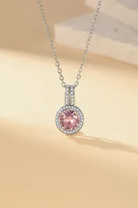 Close-up of elegant silver necklace with round pink gemstone and pave zirconia