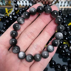 Nahaufnahme eines natürlichen Obsidian-Armbands mit starkem silbernem Glanzeffekt und Licht