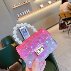 Dettaglio di una borsa jelly rosa trasparente con manico in perle e motivo trapuntato.
