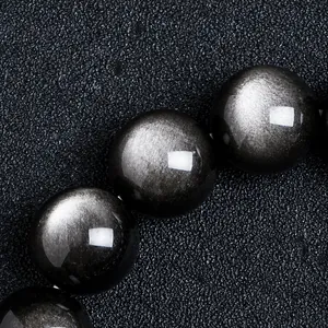 Makroaufnahme eines Armbands aus natürlichem Silber-Obsidian mit Katzenaugeneffekt