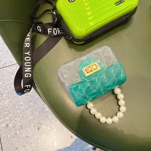 Dettaglio della mini borsa jelly in PVC trasparente trapuntata con manico in perle