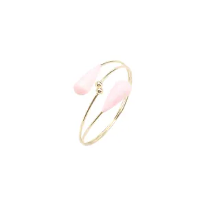 Vue détaillée d'un bracelet de bras doré avec d'élégants pendentifs gouttes roses