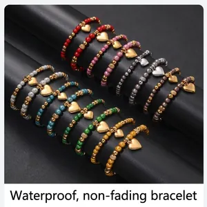 Primo piano dettagliato di braccialetti in perline colorate con ciondoli a cuore