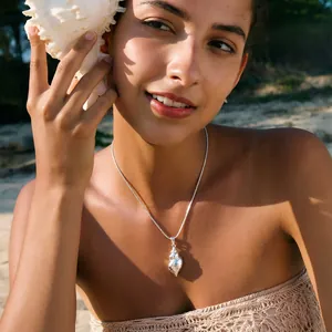 Detail of a fashion stainless steel seashell necklace worn by a woman at the beach
