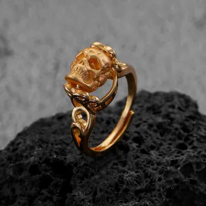 Gedetailleerde goudkleurige gotische schedelring met bewerkte band op zwarte rots