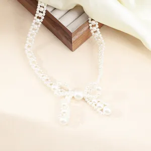 Detail view of an elegant multi-strand pearl choker featuring a large bow design