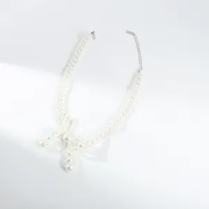 Detailed view of an elegant vintage white pearl choker necklace featuring a unique bow.