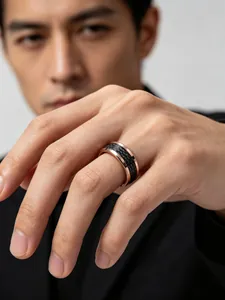 Detailed close-up view of men's rose gold tungsten ring with black carbon fiber inlay