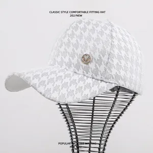 Gedetailleerd overzicht van witte kanten honkbalpet met strass M-logo en pied-de-poule.