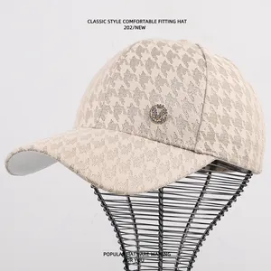 Detail beige kanten baseballcap met strass M-letter en klassiek houndstooth patroon