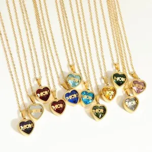 Detail view of heart-shaped birthstone necklaces featuring 'MOM' engraved pendants.
