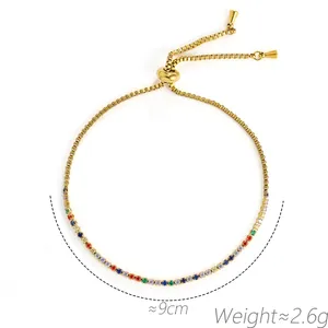 Detail van een verstelbare gouden armband met gekleurde zirkonia-stenen en gewicht