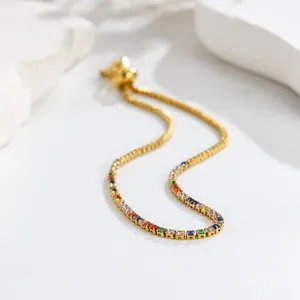 Detailweergave van de goudkleurige titaniumstalen armband met bonte edelstenen.