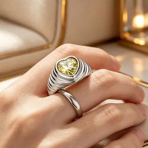 Detaillierte Makroansicht des Vintage-Wellenrings aus Edelstahl mit gelbem Herz-Edelstein