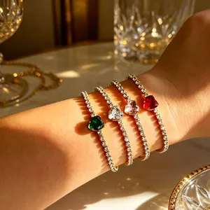 Elegante primo piano di quattro lussuosi bracciali tennis con zirconi a forma di cuore al polso.