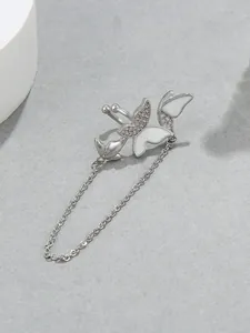 Detailed view of silver-tone butterfly ear cuff with white enamel and chain tassel