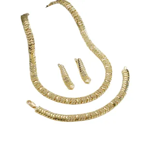 Gedetailleerd overzicht van elegante gouden visgraat sieradenset met sprankelende steen