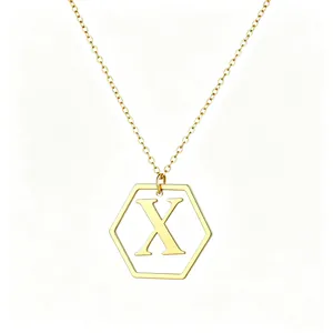 Detail view of gold hexagonal pendant with capital letter X on a delicate chain
