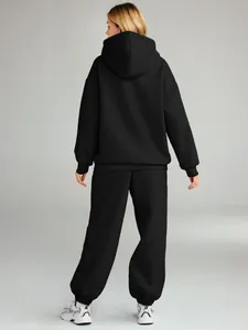 Back view of women's black oversized hoodie and sweatpants two-piece tracksuit set.