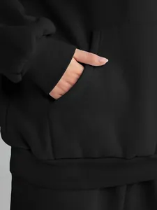 Close-up detail of front pocket on black women's oversized casual drawstring hoodie