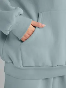 Close-up detail of pocket and ribbed cuff on light blue oversized hoodie sweatshirt