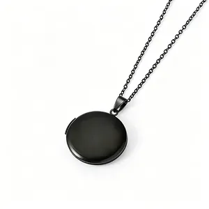 Élégant collier médaillon rond en acier inoxydable noir mat sur fond blanc neutre