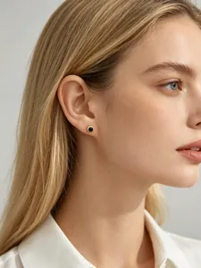 Détail d'une boucle d'oreille classique en zircon bleu rond sur l'oreille du modèle