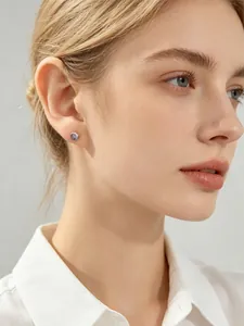 Vue détaillée d'un mannequin portant une boucle d'oreille en argent s925 et zircon violet