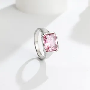 Detailed macro view of a polished silver titanium steel ring with a rectangular pink gem