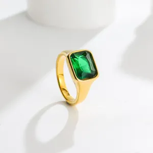 Detailed view of a green rectangular faceted gemstone set in a gold-tone band.