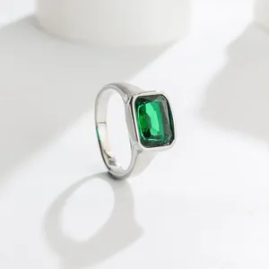 Close-up of elegant silver-toned ring with large emerald-green square gemstone