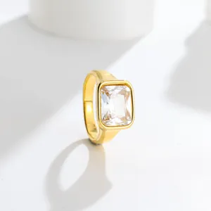 Close-up of elegant gold-toned titanium steel ring with large rectangular clear gemstone