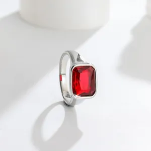 Detailed close-up of a silver titanium steel ring with a large faceted rectangular red gemstone
