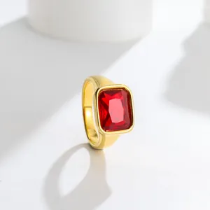 Macro view of a gold-plated stainless steel ring featuring a square red gemstone