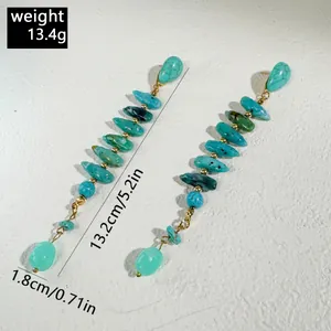 Dettaglio di lunghi orecchini a corallo turchese con dimensioni e peso indicati.