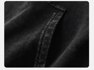Close-up detail of vintage acid-washed black hoodie showing the heavy fabric texture and seams.