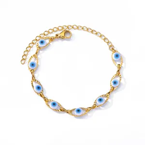 Prachtig close-up van gouden roestvrijstalen armband met blauwe boze ogen