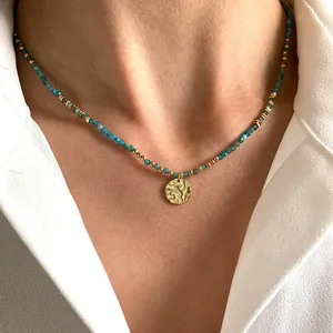 Primer plano de un collar de piedras naturales azules con colgante de oro martillado