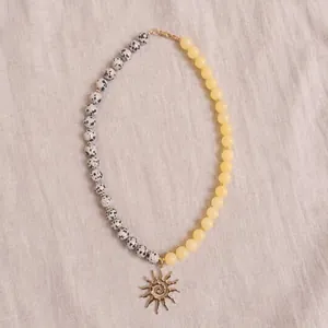 Collar bohemio de piedra natural con cuentas moteadas y amarillas y colgante de sol.