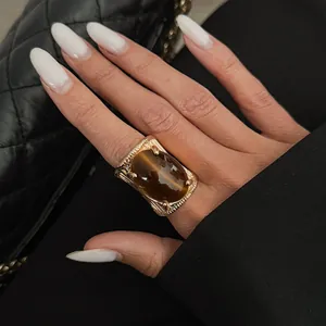 Detailed view of a vintage golden open ring with a large brown marbled gemstone