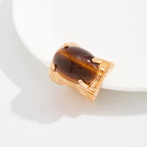 Detailed view of a vintage gold-toned wide band ring with a large oval brown gemstone accent