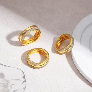 Dettaglio ravvicinato di anelli in oro 18 carati con zirconi e design intrecciato