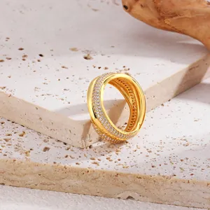 Primo piano di anello a 3 strati intrecciati placcato oro 18 carati con pietre di zircone.