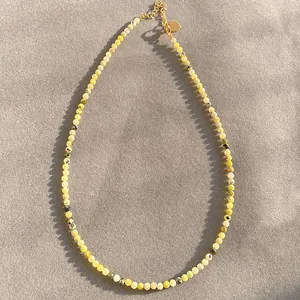 Detail view of handmade faceted yellow natural stone necklace with gold beads