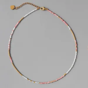 Detail of vintage faceted natural stone necklace with gold beads on grey background