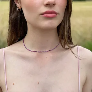 Detailed view of a vintage faceted natural stone beaded necklace with gold spacers on a model
