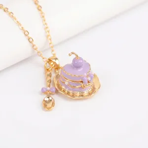 Primer plano de un collar de cupcake en esmalte púrpura con un pequeño dije de cuchara