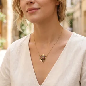 Detailed view of model wearing a vintage gold evil eye necklace with crystal fringe pendant